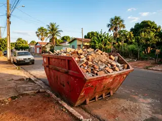 Caçamba estacionária vermelha com entulho de obra em Araguaína